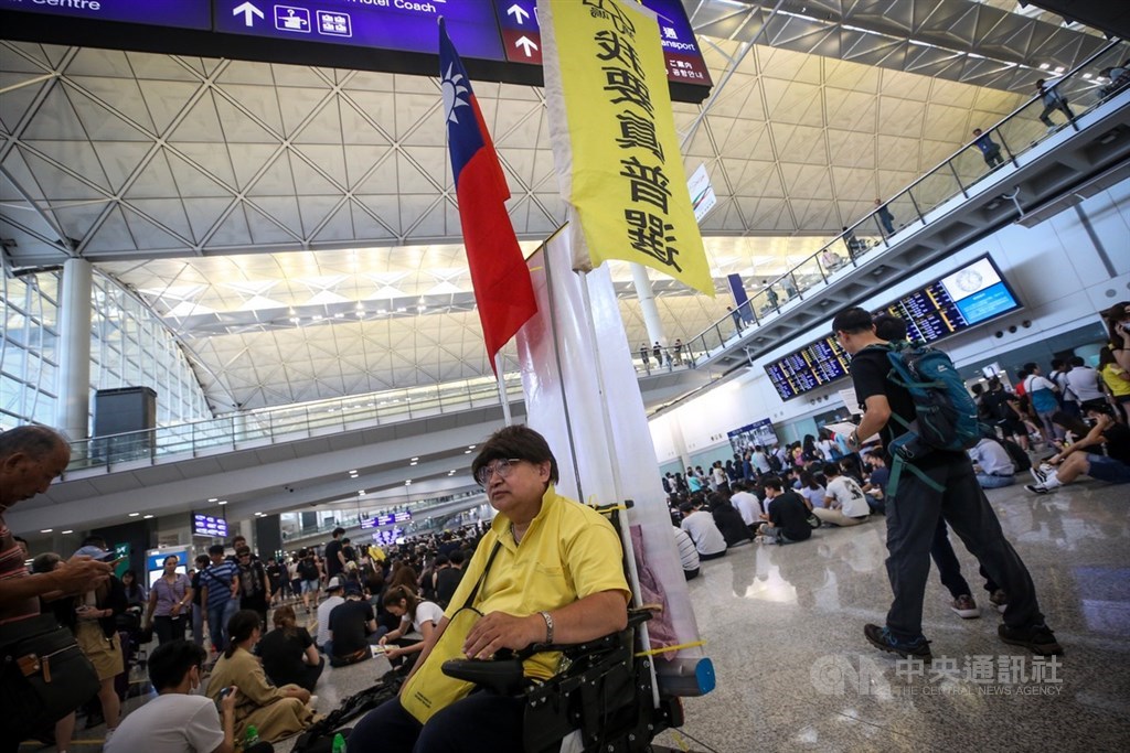 香港國際機場9日有「反送中」集會,下午4時左右,現場約有逾千人參加,大批民眾身穿黑衣在入境大廳靜坐,還有示威者帶著中華民國國旗在大廳來回穿梭。中央社記者吳家昇攝 108年8月9日