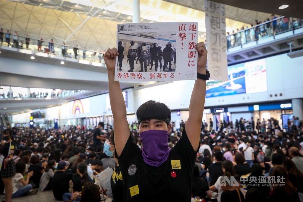 香港國際機場9日有大批黑衣民眾到場進行「反送中」集會,有參加者手持經過翻譯的文宣品,要向來自世界各地的民眾表達反送中立場,盼吸引國際關注。中央社記者吳家昇攝 108年8月9日