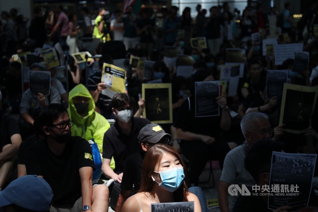 香港國際機場9日有「反送中」集會,參與民眾在入境大廳靜坐,不時呼口號或展示手中標語等,以行動力挺反送中。中央社記者吳家昇攝 108年8月9日