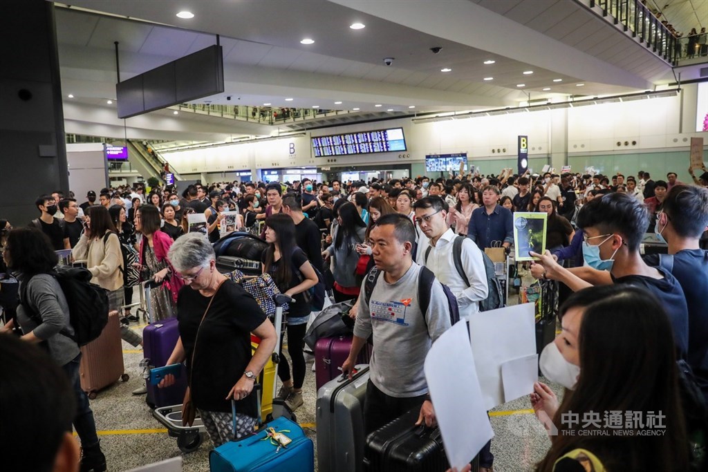 香港國際機場9日有民眾發起「反送中」集會,晚間9時左右仍有逾千人穿著黑衣響應,有參加者手持文宣品並向入境旅客呼口號,表達反送中立場。中央社記者吳家昇攝 108年8月9日