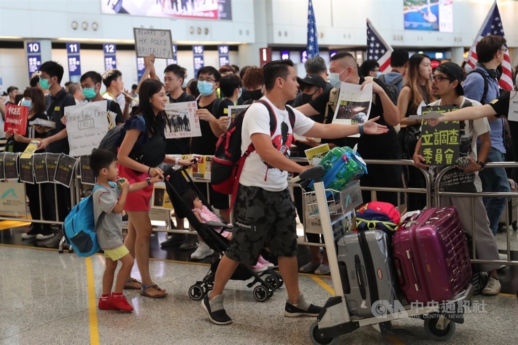 香港國際機場9日有民眾發起「反送中」集會,大批黑衣人在入境大廳靜坐,也有部分示威者選擇在大廳發放文宣品爭取支持。中央社記者吳家昇攝 108年8月9日
