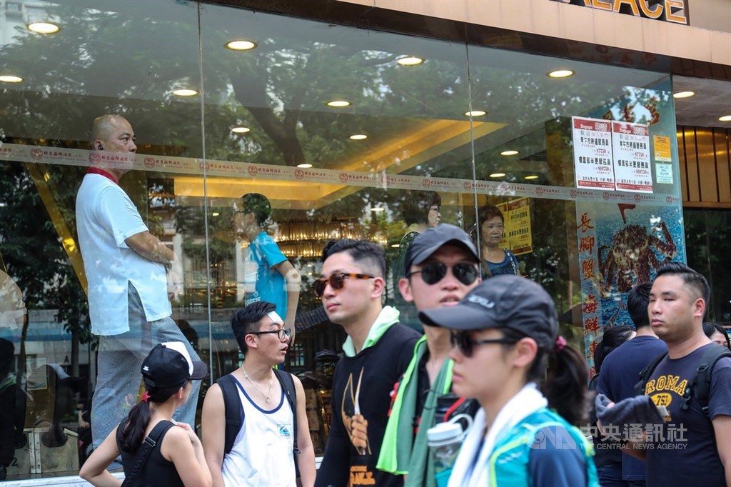 香港10日持續有「反送中」集會遊行,其中包括遭警方否決的大埔遊行,參與群眾所經之處也吸引不少人目光,有些人默默在一旁商家內關注這場遊行。中央社記者吳家昇攝 108年8月10日