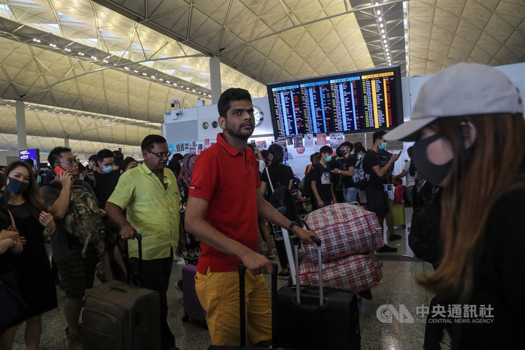 香港機場管理局12日下午近4時表示,受機場集會影響,除了已完成航班登機的離港航班,以及正前往香港的抵港航班,其餘航班全取消,所有登機服務即時暫停。旅客持續在機場內等候。中央社記者吳家昇攝 108年8月12日