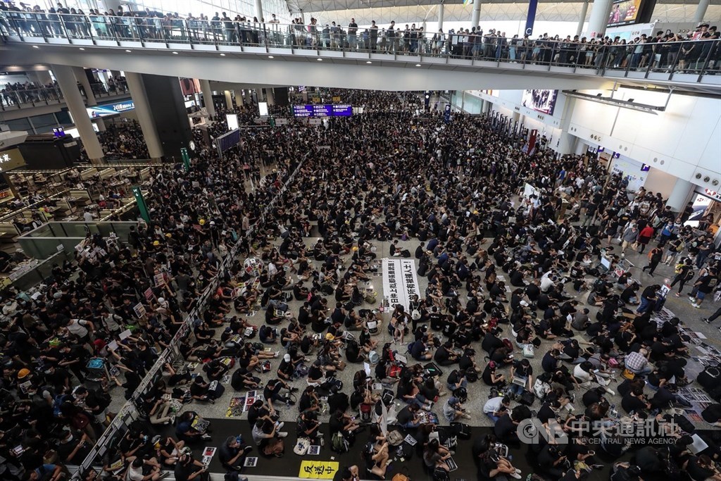 香港「反送中」警民衝突升高,一名女子8月11日在示威中遭警方射傷右眼,引發黑衫軍強烈憤慨,號召反送中支持者12日全面罷工,中午1時進入機場,要求「黑警還眼」、「五大訴求,缺一不可」。中央社記者吳家昇攝 108年8月12日