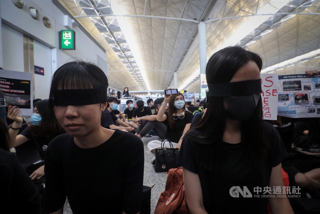 香港「反送中」抗爭11日遭警方空前強勢鎮壓,一名示威女子遭射傷右眼,引發黑衫軍強烈憤慨,12日中午1時號召全民罷工,民眾以黑布遮眼,要求「警察還眼」。中央社記者吳家昇攝 108年8月12日