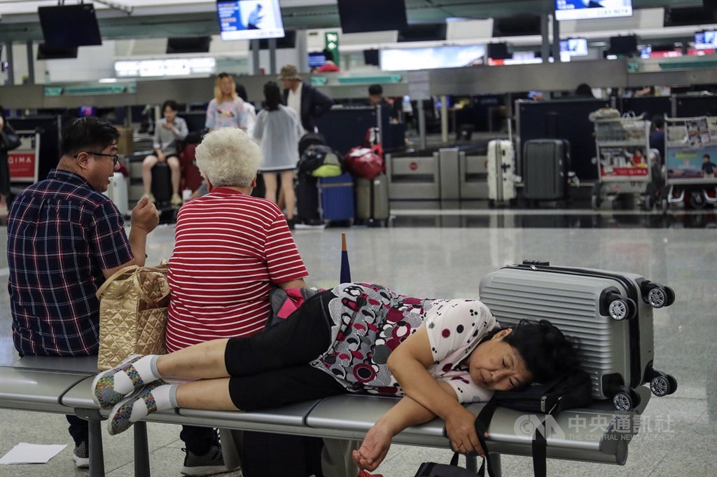 香港「反送中」抗爭延燒,香港機場12日下午近4時宣布取消所有航班,機場內不少旅客無奈等待後續消息。中央社記者吳家昇攝 108年8月12日