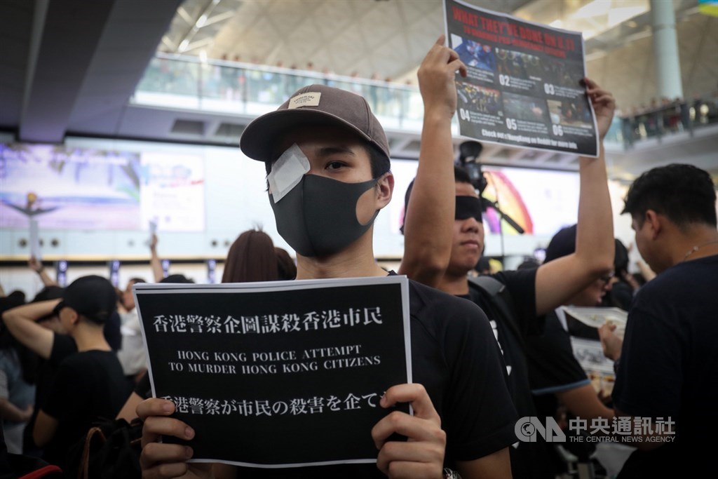 香港「反送中」抗爭11日遭警方空前強勢鎮壓,一名示威女子遭射爆右眼引發黑衫軍強烈憤慨,號召12日中午1時全民罷工,百萬人塞爆機場,民眾以眼罩遮住右眼,要求「黑警還眼」。中央社記者吳家昇攝 108年8月12日