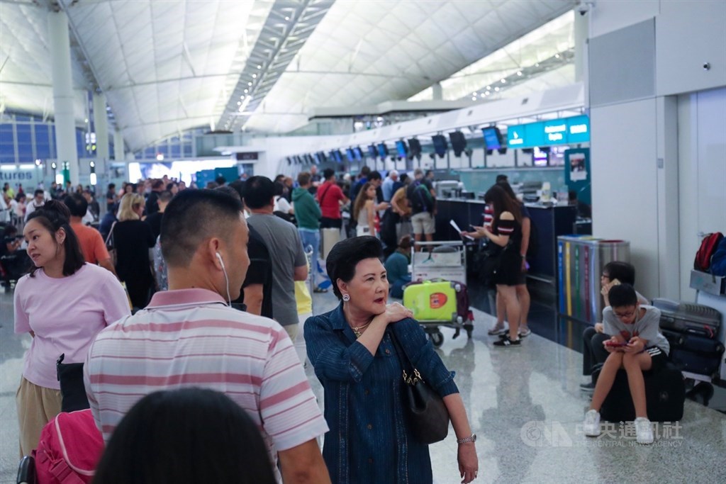 香港反送中示威者號召全民罷工、百萬人塞爆機場,造成香港機場12日下午4時起全數航班取消,13日班機航班大亂,旅客在櫃台前排隊等候。中央社記者吳家昇攝 108年8月13日
