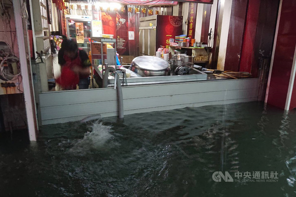 台南地區12日晚間開始下起大雷雨,13日台南市政府也緊急宣布停班停課一天。永康區大灣路淹水,店家趕緊將防水閘門裝上。中央社記者楊思瑞攝 108年8月13日