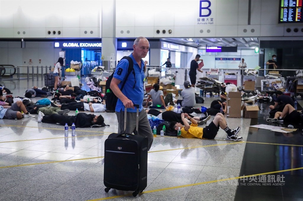 香港反送中示威者號召全民罷工、百萬人塞爆機場,造成香港機場12日下午4時起全數航班取消,13日清晨5時示威者剩不到百人,旅客在示威者身處的大廳穿梭。中央社記者吳家昇攝 108年8月13日