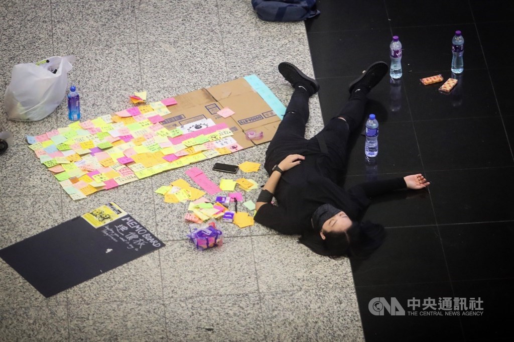 香港反送中示威者號召全民罷工、百萬人塞爆機場,造成香港機場12日下午4時起全數航班取消,13日清晨5時示威者剩不到百人,示威者在大廳就地休息。中央社記者吳家昇攝 108年8月13日