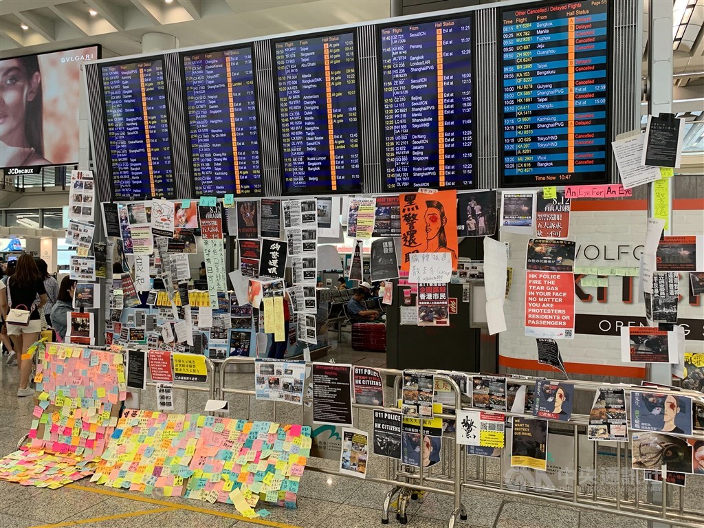 香港機場13日陸續恢復運作,機場內仍張貼示威標語。中央社 108年8月13日