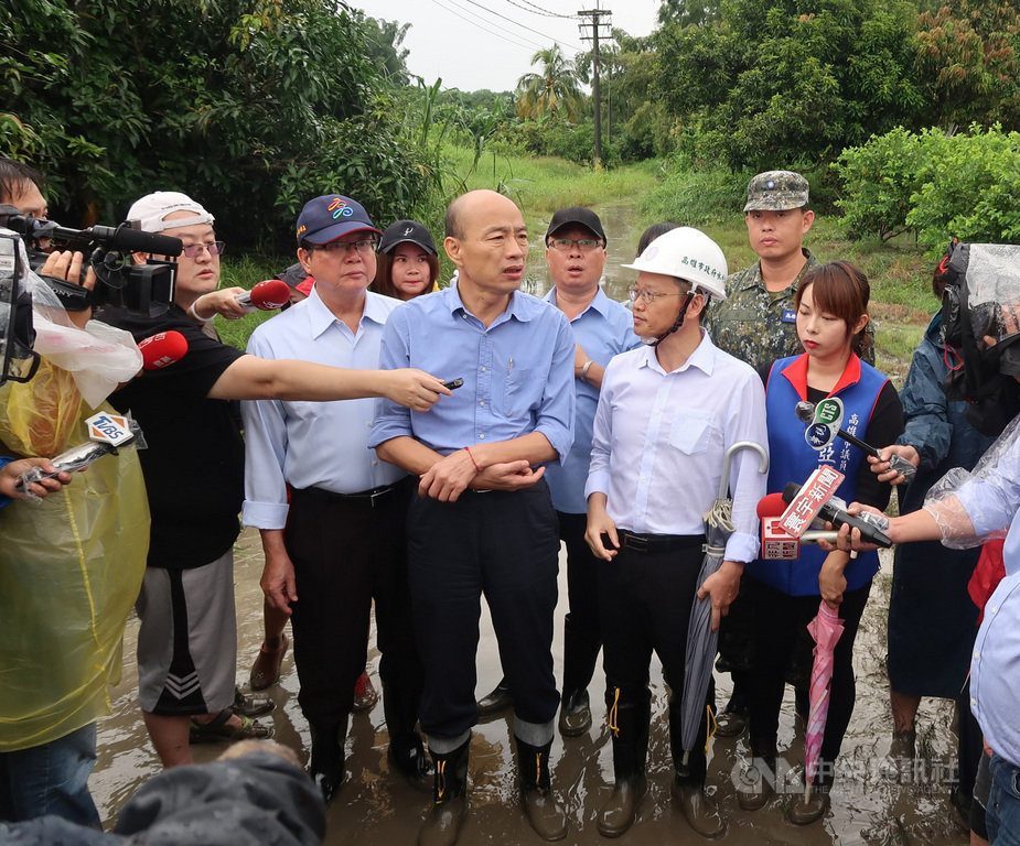 高雄市13日一場大雷雨造成多處有積淹水災情,高雄市長韓國瑜(前中)由工務局長吳明昌(前左2)及水利局長李戎威(前右2)陪同勘災。中央社記者王淑芬攝 108年8月13日