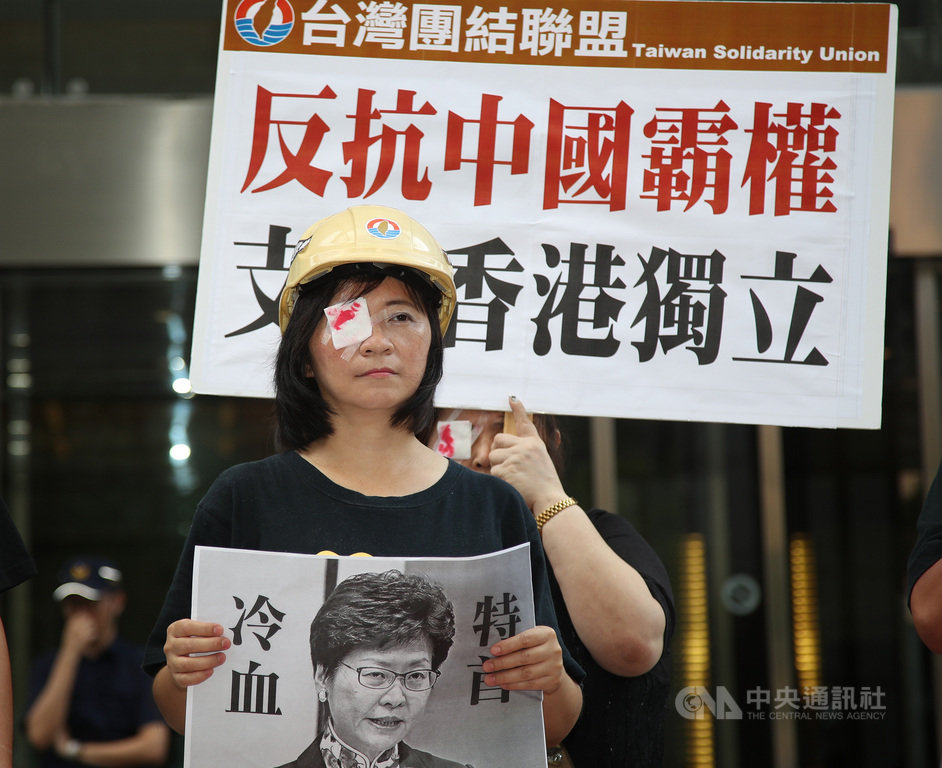 台灣團結聯盟14日在位於台北的香港經濟貿易文化辦事處前,舉行「聲援香港人民反送中,譴責港府警血腥鎮壓」記者會,台灣團結聯盟組織部主任、前立委周倪安右眼戴上紗布,表達訴求。中央社記者張新偉攝 108年8月14日