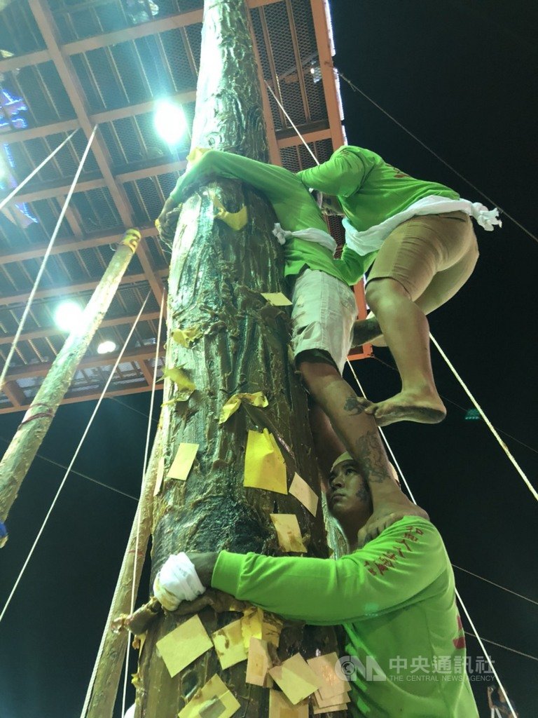 屏東恆春中元節豎孤棚競賽15日晚間9時熱鬧登場,比賽緊張刺激,選手們攀爬塗滿牛油的孤棚柱,十分挑戰智慧、技巧、毅力及團隊精神。中央社記者郭芷瑄攝 108年8月15日