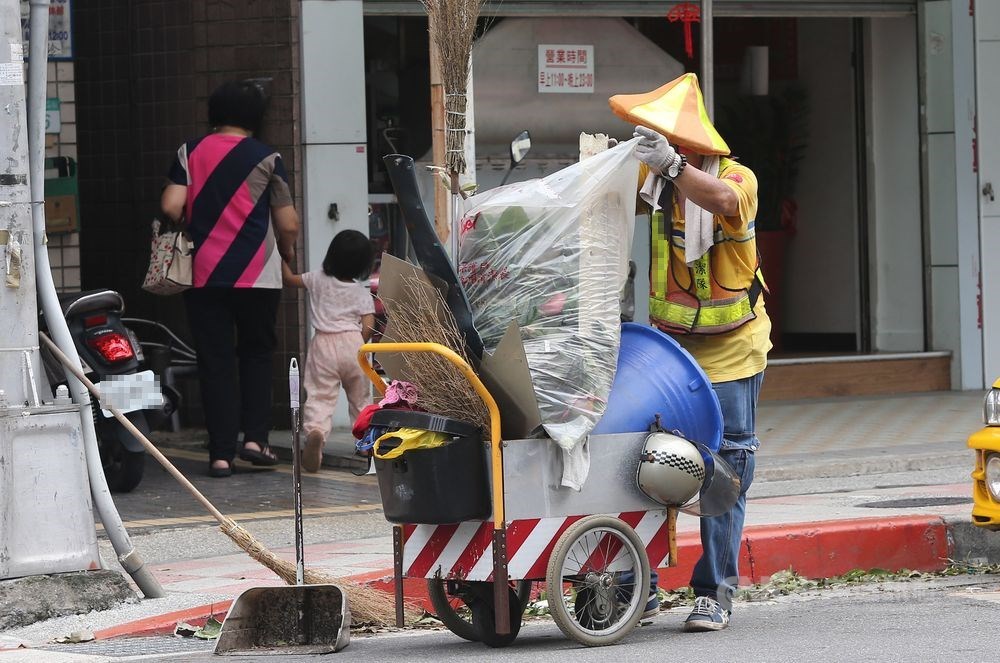 有民眾向媒體投訴,指台北市環保局禁止清潔人員穿制服進入便利商店,副局長盧世昌16日說,並非禁止,而是曾多次接獲民眾投訴指清潔隊員在便利商店打牌、喧嘩,才發公文。圖為清潔隊員清掃街頭。(示意圖/中央社檔案照片)