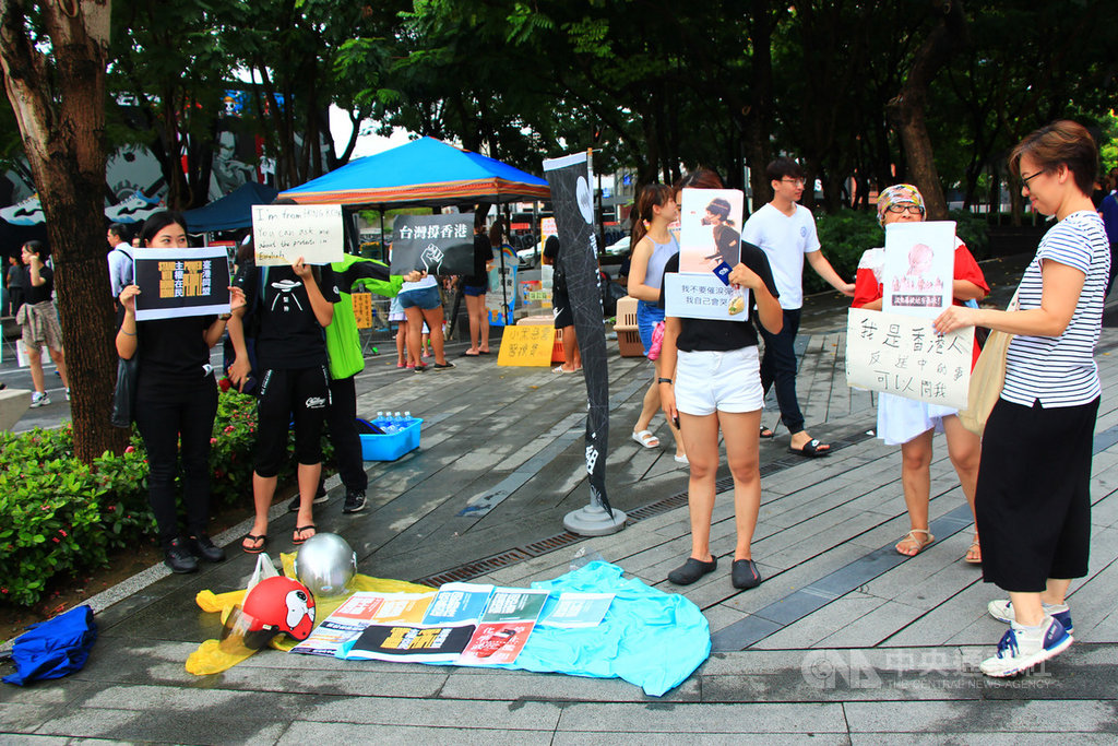由在台香港青年組成的團體「香港邊城青年」17日原定在台中市市民廣場發起野餐交流活動,但因午後大雨,活動臨時改為在草悟道旁人行道快閃擺攤,多名在台港人現場高舉標語、看板表達訴求。中央社記者蘇木春攝 108年8月17日