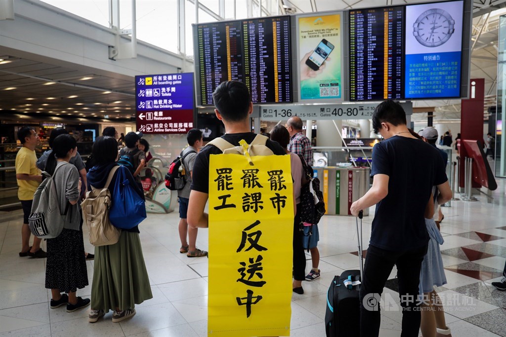 香港反送中示威者日前癱瘓機場運作,數以百計航班取消。圖為旅客帶著文宣品聲援反送中示威者。 中央社記者吳家昇攝 108年8月14日