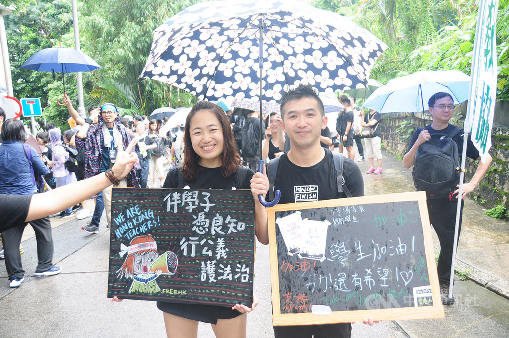 香港教協17日發起遊行,在小學任教的黃老師(右)手持黑板粉筆,為學生加油。中央社記者沈朋達香港攝 108年8月17日