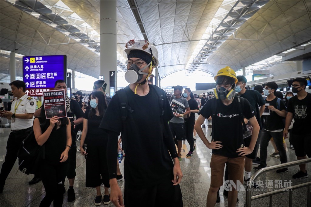 反送中抗議民眾所使用的頭盔、口罩等裝備,已被香港電商平台列為「敏感物品」,得由中國以外的地方購買。圖為12日民眾於香港機場集會情形。(中央社檔案照片)
