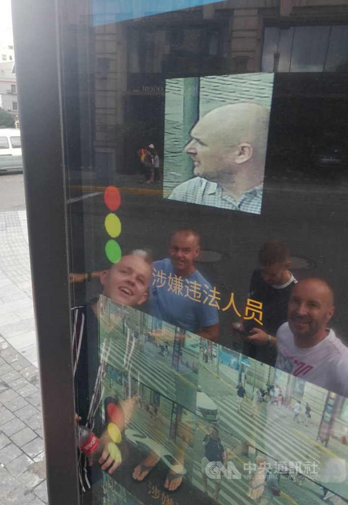一群外國遊客在上海外灘看見同行友人的臉部影像在街頭「輪播」,還誤以為是什麼有趣的事,直到記者向他們說明,才知道友人闖紅燈被拍下。中央社記者陳家倫上海攝 108年8月20日