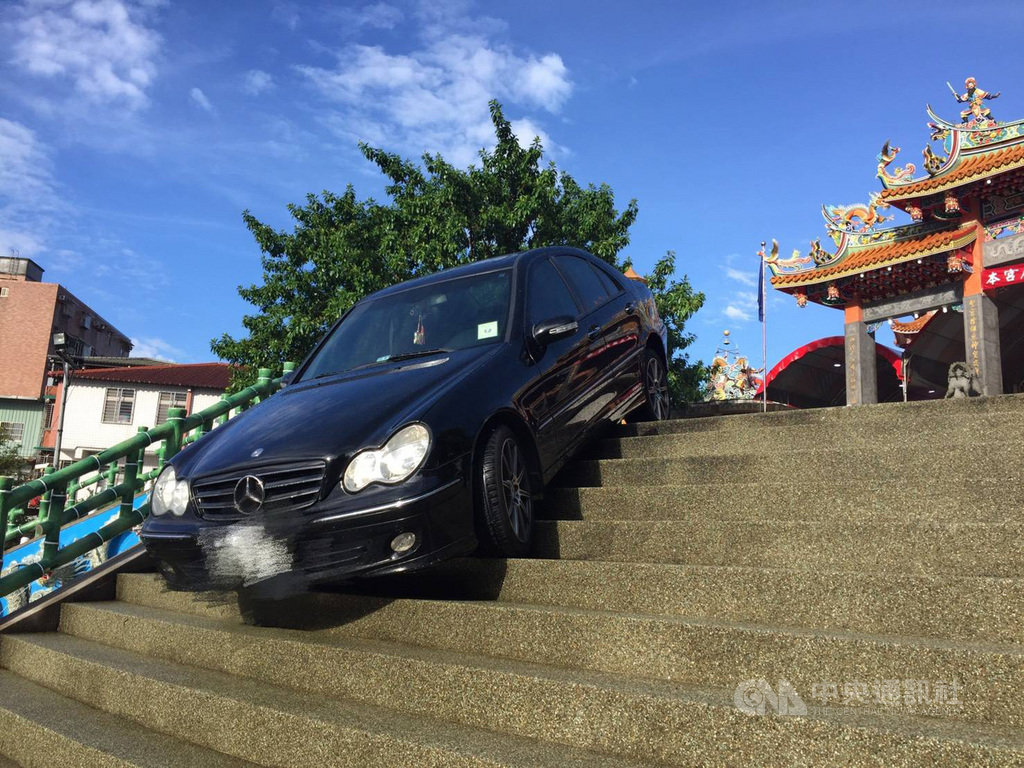 新北市淡水天元宮前21日發生一起賓士車卡在台階意外,警方指出,駕駛疑因不慎誤踩油門失控,車輛才會衝到台階,經拖吊車處理後車子脫困。(翻攝畫面)中央社記者王鴻國傳真 108年8月21日