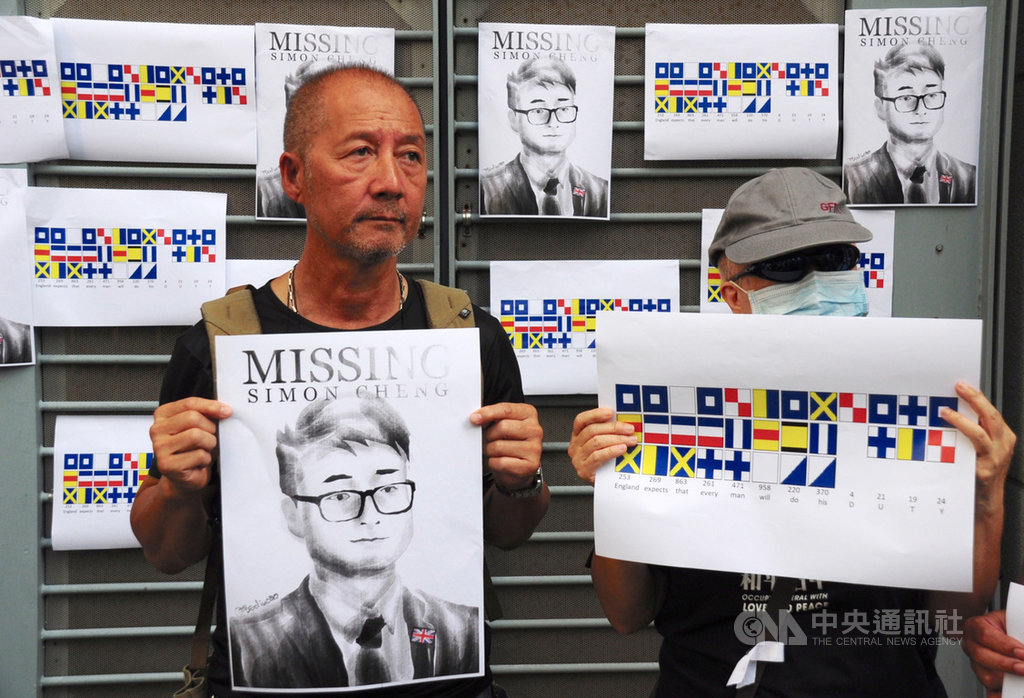 數10位港人21日聚集在英國駐港總領事館外,高喊「Save Simon now, Delay no more 」口號,並將印有鄭文傑頭像的海報張貼在領事館外牆,呼籲英國政府積極救援。中央社記者沈朋達香港攝 108年8月21日
