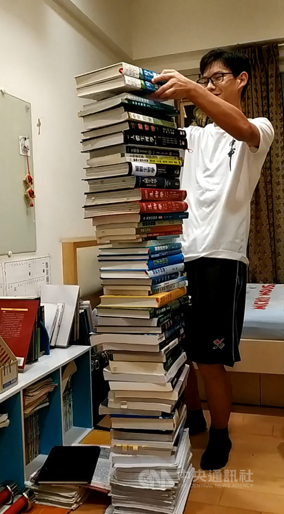 台中一中4名學生挑戰國際奧林匹亞競賽,獲得3金1銀佳績,其中李祥宇為了準備比賽,自學念完50多本書籍,書本疊起來快接近他的身高178公分。(李祥宇提供)中央社記者趙麗妍傳真 108年8月21日