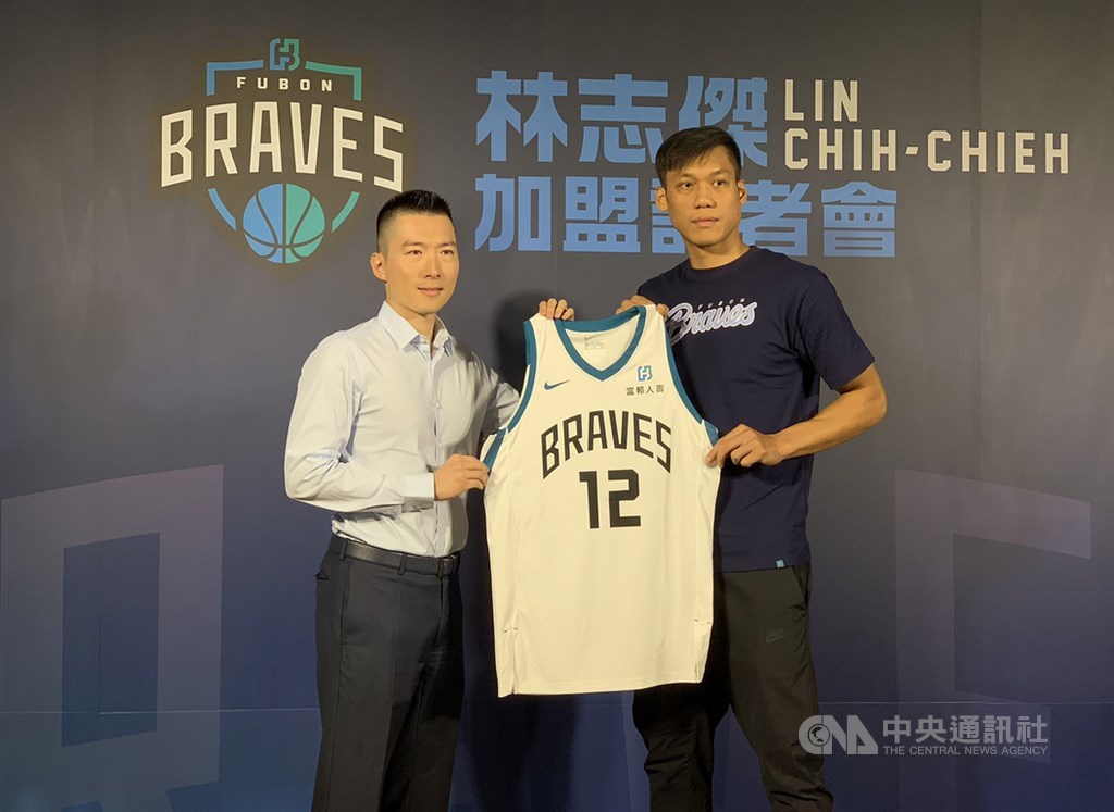 台灣籃球好手「野獸」林志傑(右)加盟富邦勇士記者會22日下午在台北舉行,富邦育樂總經理暨富邦勇士隊領隊蔡承儒(左)送上球衣。中央社記者張新偉攝 108年8月22日