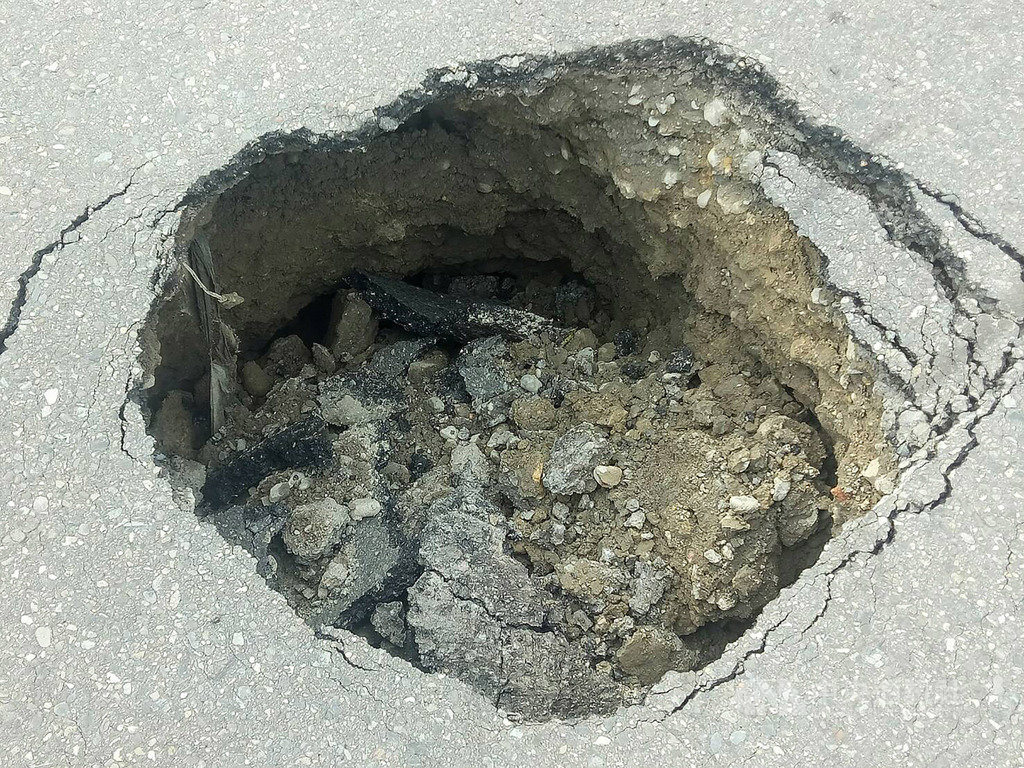 高雄市美術東二路與明誠四路口23日下午出現一個大洞,水利局表示,下午3時30分左右接獲當地里長通報這處坑洞,立即派員檢視,初步懷疑是當地下水道管線破損造成道路坍塌,已派員搶修中,周邊維持交管。(民眾提供)中央社記者程啟峰高雄傳真 108年8月23日