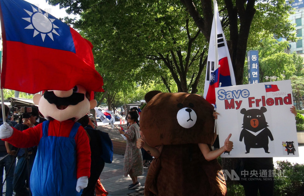 韓國網路媒體Media Watch與訂閱者民間團體23日在首爾光化門駐韓代表部前廣場聚會,高舉中華民國國旗及台灣喔熊布偶為台灣自由茁壯加油。中央社記者姜遠珍首爾攝 108年8月23日