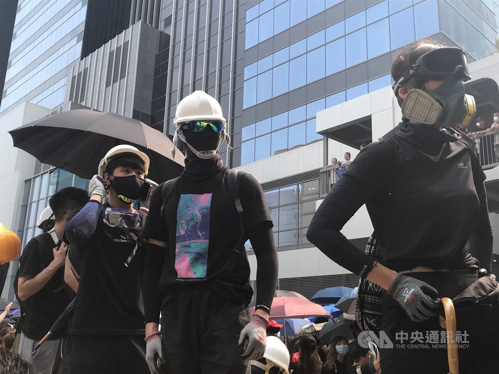 香港觀塘24日下午舉行反送中遊行,遊行結束後,示威者包圍牛頭角警署,與警署外的防暴警察對峙,並戴上抗爭防護裝備。中央社記者沈朋達香港攝 108年8月24日