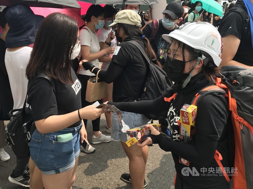 香港觀塘24日下午有反送中遊行。有示威者在觀塘海濱公園發鋁箔紙給民眾。他們表示,擔心智慧型燈柱掃描到身分證或回鄉證,因此可用鋁箔紙包住,避免日後被秋後算帳。中央社記者沈朋達香港攝 108年8月24日