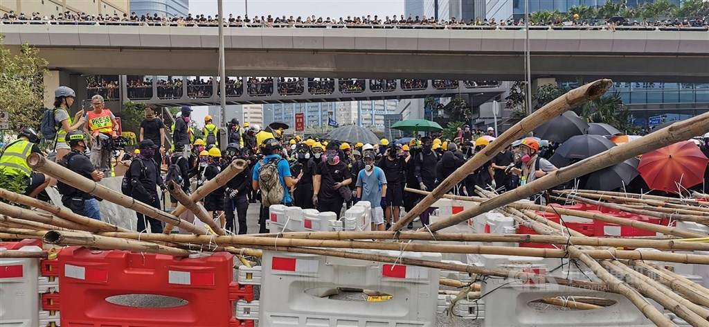 香港24日下午又有「反送中」遊行,地點在九龍觀塘。圖為部分示威者在遊行後包圍牛頭角警署,並在偉業街築防線,與警署外的防暴警察對峙。中央社記者張謙香港攝 108年8月24日