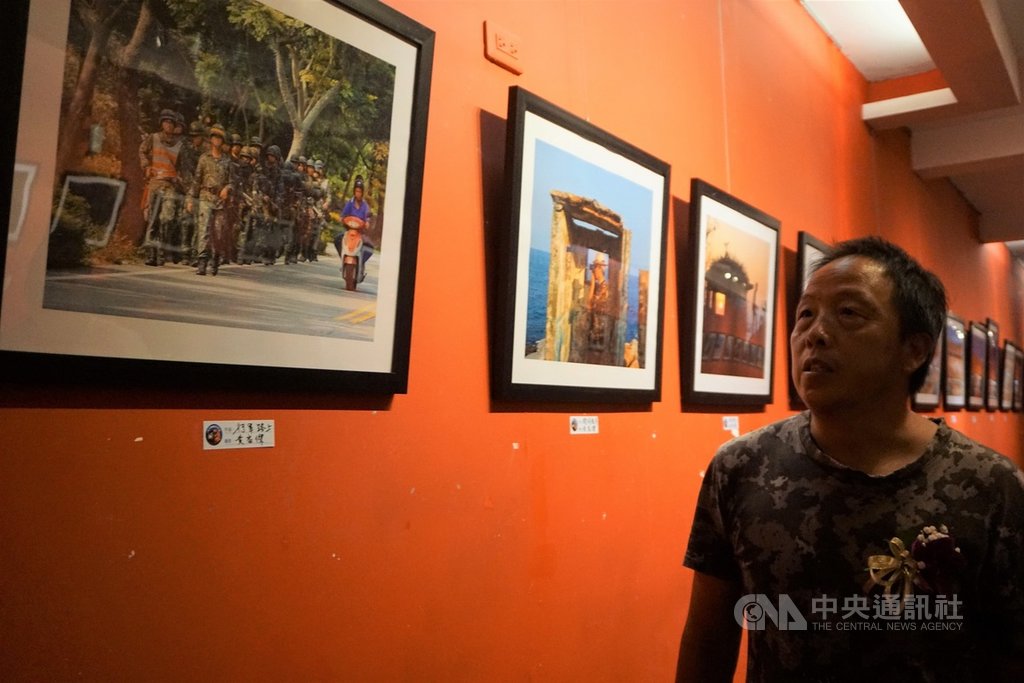 「戰地.讚地」攝影聯展正在金門縣文化局展出,金門縣攝影學會成員黃家傑的「行軍路上」,勾起觀者回憶,學會理事長許進西(圖)等人感嘆,現在街上都很難看到軍人了。中央社記者黃慧敏攝 108年8月25日