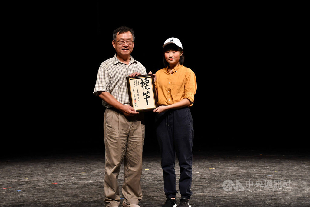 澎湖縣長賴峰偉(左)25日頒贈親筆墨寶給今年榮獲總統教育獎的家扶中心扶助兒少陳女真(右),感謝社會能共聚能量,支持澎湖孩子發光發熱。中央社 108年8月25日