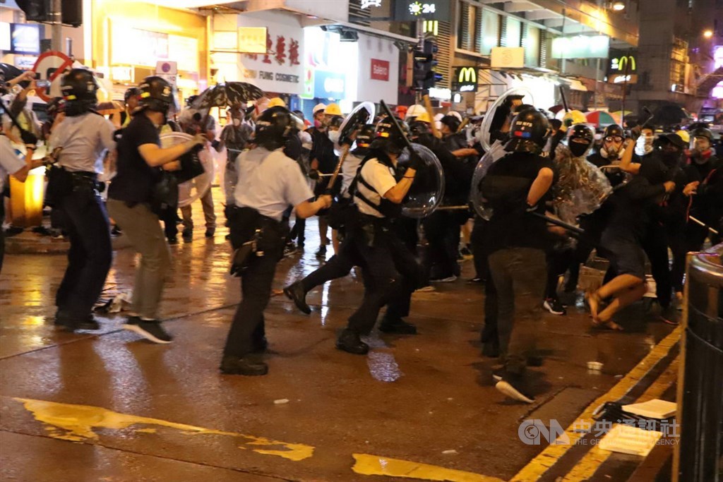 香港「反送中」遊行25日晚疑似首度出現警方發射實彈。入夜後,有約10名員警在抗爭現場遭示威者包圍追打,被圍員警拔出隨身的左輪手槍對空鳴槍示警,示威者一哄而散,並遭增援的員警追捕。圖為混戰場景。中央社記者張謙香港攝 108年8月25日