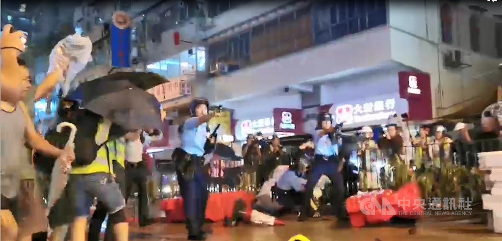 香港「反送中」遊行今晚疑似首度出現警方發射實彈。入夜後,有約10名員警在抗爭現場遭示威者包圍追打,被圍員警拔出隨身的左輪手槍對空鳴槍示警,示威者一哄而散,並遭增援的員警追捕。中央社記者張謙香港攝 108年8月25日