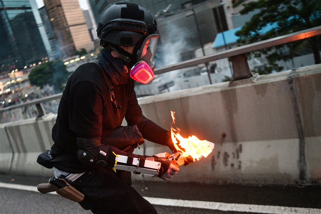 一名示威者8月31日在夏愨道陸橋丟汽油彈時,被法新社記者華勒斯拍到腰間配有一把疑似「克拉克19」型手槍,一度被懷疑是警方臥底。(法新社提供)