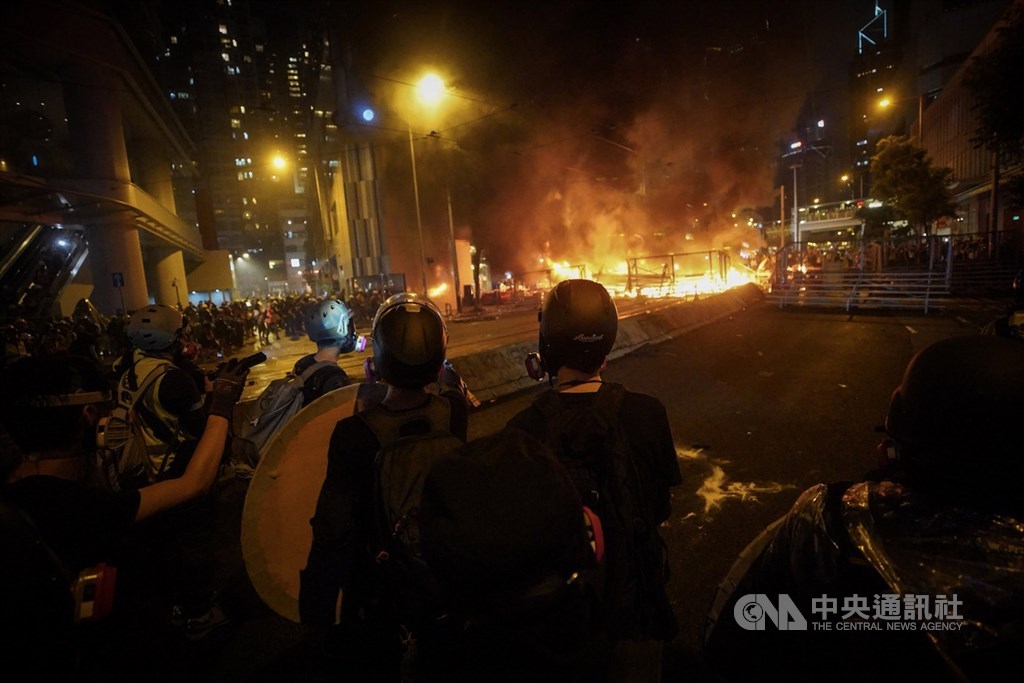 香港反送中運動31日傍晚上演暴力抗爭場面,除警方發射催淚彈、出動水砲車外,示威者也頻丟汽油彈等,雙方對峙至入夜仍持續,灣仔一帶街道燃起熊熊火光。中央社記者吳家昇香港攝 108年8月31日