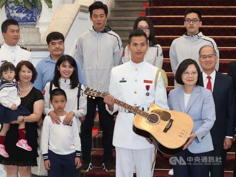 海軍蘇祈麟上兵(前右2)2018年赴美參加「世界儀隊錦標賽」個人組比賽,榮獲創辦人特別獎,總統蔡英文(前右)在總統府接見蘇祈麟及家屬,並送一把簽名吉他給喜愛彈吉他的蘇祈麟。(中央社檔案照片)