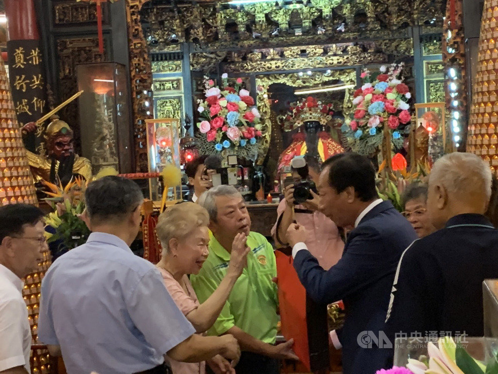 台北市長柯文哲(左2)與鴻海創辦人郭台銘(前右2)11日一早到新竹都城隍廟參拜,郭台銘向柯文哲母親何瑞英(左3)打招呼致意。中央社記者郭宣彣攝 108年9月11日