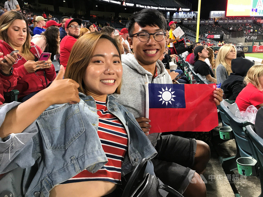 台灣球迷侯致遠(右)、彭筠雅(左)10日帶著國旗在天使球場為台灣選手張育成加油。他們以自己在海外工作的經驗指出,張育成能夠在大聯盟占有一席之地,真的不容易。中央社記者林宏翰洛杉磯攝 108年9月11日