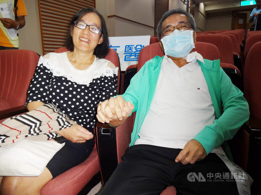 高雄醫學大學附設中和紀念醫院11日召開「花好月圓妻捐肝救夫慶團圓」記者會,胡姓男子(右)與妻子(左)十指緊扣,夫妻倆同「肝」共苦,憶起捐肝過程,也提醒民眾要多注意健康。中央社記者陳朝福攝 108年9月11日