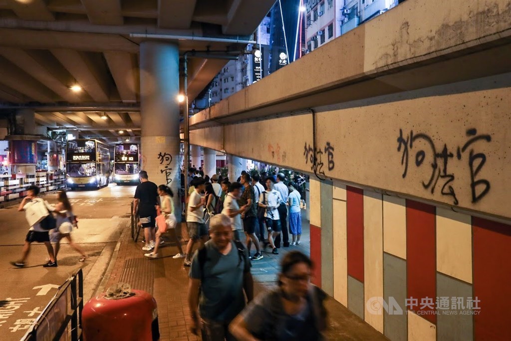 日常的香港街頭一切如常,只有牆上的噴漆提醒著現在仍在抗爭中。
