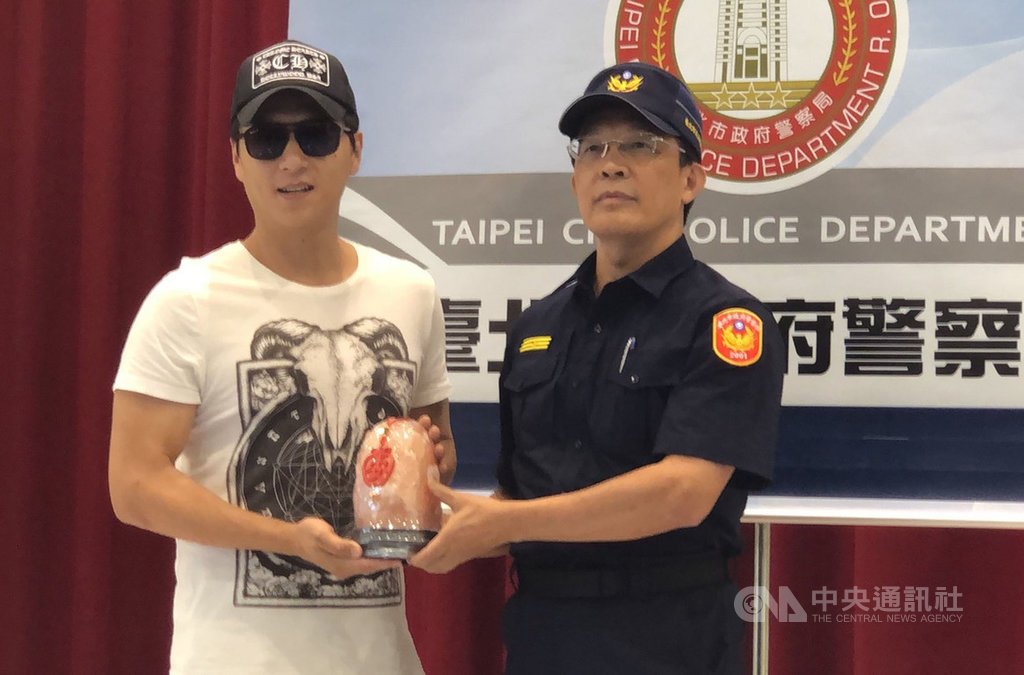 男星鄭人碩(左)日前在西門町超商內發現員警壓制一名毒犯,立即上前助警戒護。台北市萬華警分局12日致贈紀念品給鄭人碩,感謝他以行動支持警方。中央社記者劉建邦攝 108年9月12日