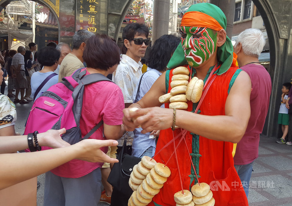 「2019雞籠城隍文化祭」系列活動「日巡遶境」14日下午熱鬧登場,民眾爭相向開路的家將索取鹹光餅,祈求平安。中央社記者王朝鈺攝 108年9月14日