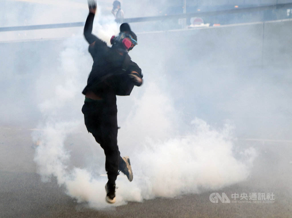 香港示威者15日下午包圍政府總部並丟擲汽油彈等,傍晚警方開始清場。政府總部外,一名示威者撿到催淚彈,把它往政總內部投擲。中央社記者張謙香港攝 108年9月15日