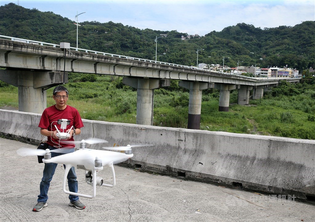 攝影記者鄭傑文20年後重回現場 ,背後是豐原往東勢的埤豐大橋。(中央社記者郭日曉攝)
