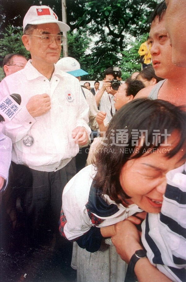 副總統連戰在埔里災區視察,痛失家人的民眾哭倒在親友身上。(檔案照片/王飛華攝)
